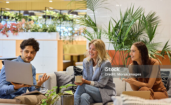 Photo of a workers watching their coworker present to them from a laptop
