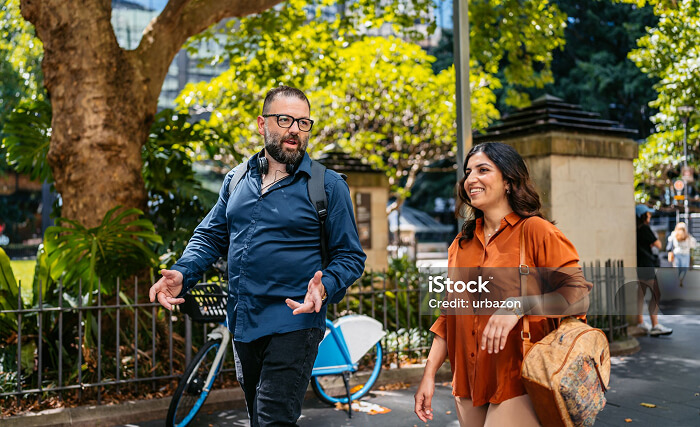 Photo of a man and woman walking together, smiling at each other