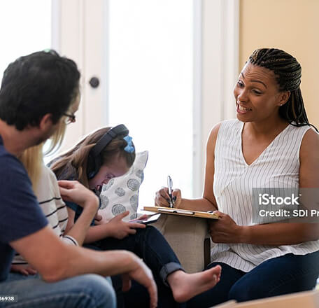 A therapist, a parent and child having a discussion