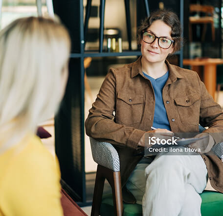 Two women sat down facing each other