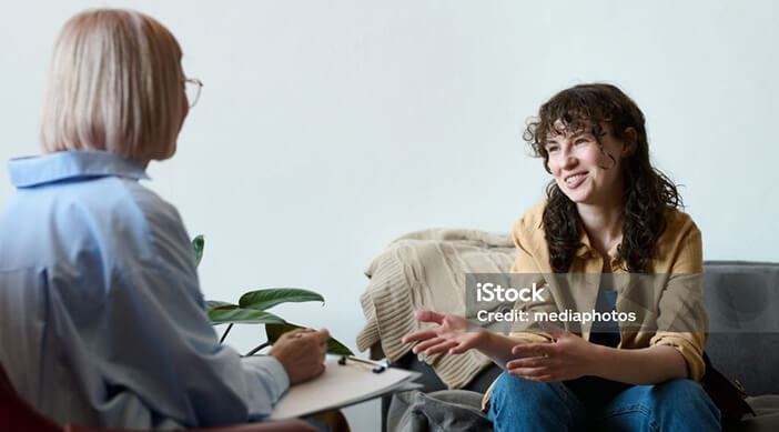 Photo of two women chatting on sofa