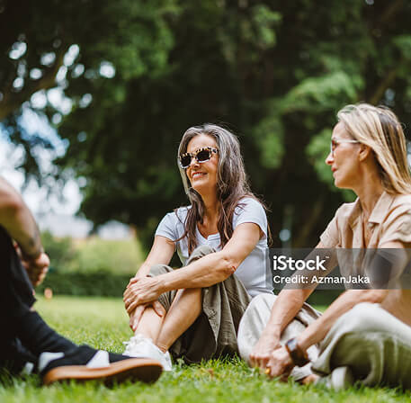 Photo of a group sitting on the grass in a park setting